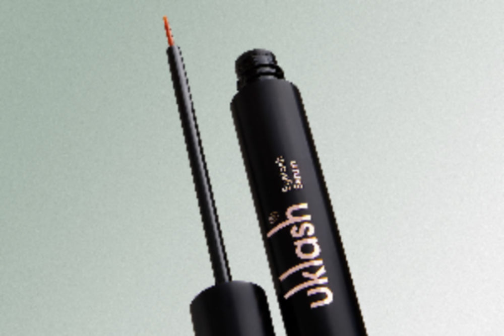 UKLASH Eyelash Serum with an open applicator against a light background.